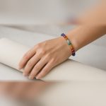 Manka 7 Chakra Bracelet worn on the wrist over a yoga mat