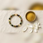 Dhanyog bracelet with a brass bowl of rice and white petals